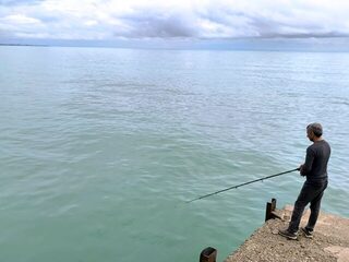 Новый Афон, Абхазия: ловля донных рыб с пирса на Чёрном море в холодной морской воде весной