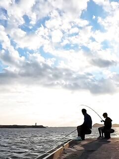 На Чеджу отец и сын вместе занялись удочками у моря