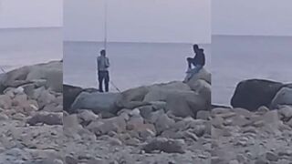 Вечер у моря Лимасол человек с удочкой и фонари по кромке волнорезов