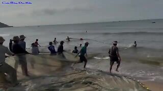 Утренняя помощь рыбакам с неводом на пляже Лонгхай во Вьетнаме