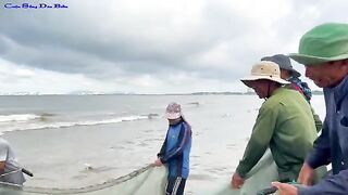 Утренняя помощь рыбакам с неводом на пляже Лонгхай во Вьетнаме
