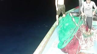 Ночная работа рыбаков в бухте Куинёна: лодка, свет и сеть