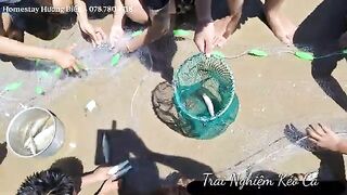 Лонгхай: гости помогают рыбакам тянуть невод на пляже