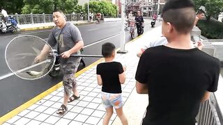 Рыбалка в центре Shanghai городские набережные парки и удивлённые прохожие вокруг рыбака