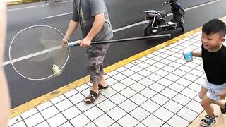 Рыбалка в центре Shanghai городские набережные парки и удивлённые прохожие вокруг рыбака