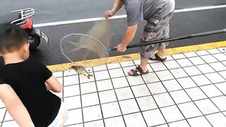 Рыбалка в центре Shanghai городские набережные парки и удивлённые прохожие вокруг рыбака