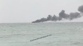 Unawatuna Sri Lanka рыбацкое судно в огне пожар у берега и работа спасателей в море