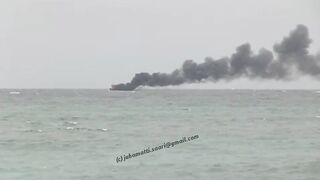 Unawatuna Sri Lanka рыбацкое судно в огне пожар у берега и работа спасателей в море