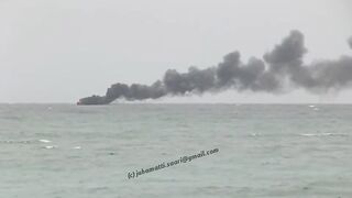 Unawatuna Sri Lanka рыбацкое судно в огне пожар у берега и работа спасателей в море