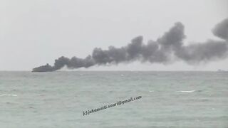 Unawatuna Sri Lanka рыбацкое судно в огне пожар у берега и работа спасателей в море