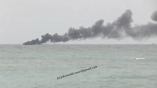 Unawatuna Sri Lanka рыбацкое судно в огне пожар у берега и работа спасателей в море