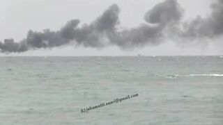 Unawatuna Sri Lanka рыбацкое судно в огне пожар у берега и работа спасателей в море