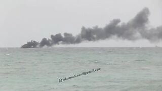 Unawatuna Sri Lanka рыбацкое судно в огне пожар у берега и работа спасателей в море