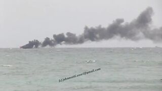 Unawatuna Sri Lanka рыбацкое судно в огне пожар у берега и работа спасателей в море