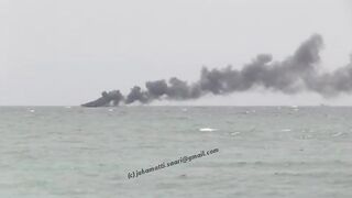 Unawatuna Sri Lanka рыбацкое судно в огне пожар у берега и работа спасателей в море