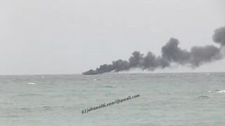 Unawatuna Sri Lanka рыбацкое судно в огне пожар у берега и работа спасателей в море