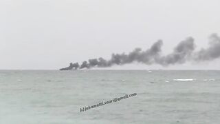 Unawatuna Sri Lanka рыбацкое судно в огне пожар у берега и работа спасателей в море