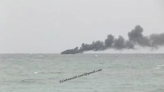 Unawatuna Sri Lanka рыбацкое судно в огне пожар у берега и работа спасателей в море