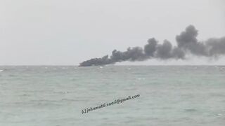 Unawatuna Sri Lanka рыбацкое судно в огне пожар у берега и работа спасателей в море