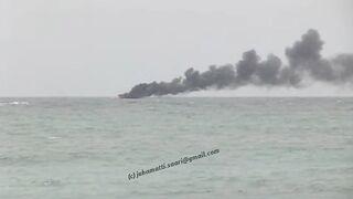 Unawatuna Sri Lanka рыбацкое судно в огне пожар у берега и работа спасателей в море