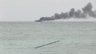 Unawatuna Sri Lanka рыбацкое судно в огне пожар у берега и работа спасателей в море