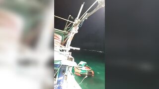 Ночная рыбалка на кальмаров остров Фукуок Вьетнам лодка огни в темноте и крошечные трофеи в ведре