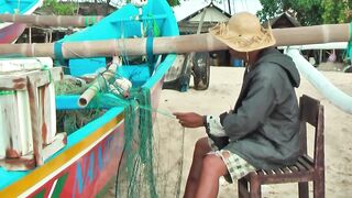 Рыбаки Jimbaran Bali живут и работают прямо на пляже от сети до вечерней рыбалки