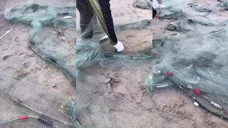 Рыбаки на пляже вечерний улов сети лодки и закат над морем