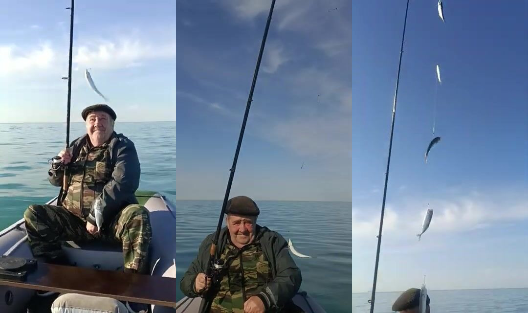 Рыба в руках на моторной лодке у Сочи