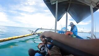 Рыбу на синей лодке у Бали уже держат в руках