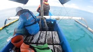Рыбу на синей лодке у Бали уже держат в руках