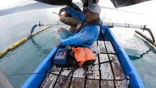 Рыбу на синей лодке у Бали уже держат в руках