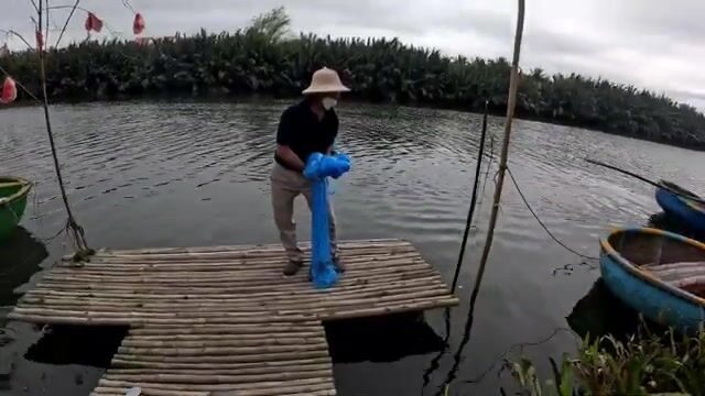 Две рыбы в длинную сеть с корзинной лодки в Хойане