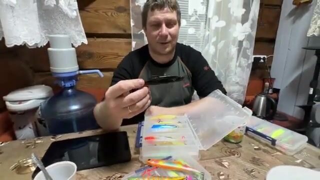 Саша показывает и выбирает приманки перед рыбалкой на судака на Горьковском море