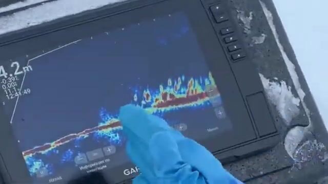 Саша показывает и выбирает приманки перед рыбалкой на судака на Горьковском море